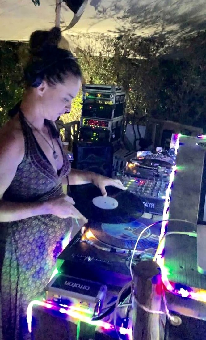 DJ Miss Black mixing vinyl under a canopy strung with fairy lights
